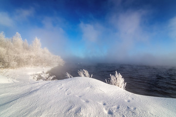 зимний пейзаж на Уральском озере с туманом и деревьями в снегу, Россия, январь