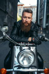 Fototapeta na wymiar Bearded biker on classical chopper, front view
