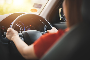 Close Up of Woman Driving a Car on Road on Daylight with Soft Sunlight Flare - Transportation...