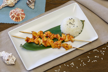 Chicken kebab and rice on a plate, top view