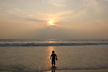 Naklejka premium sylwetka człowieka na plaży o zachodzie słońca