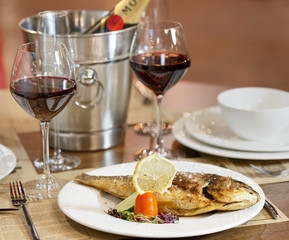 Dinner at the restaurant, dish and wine on the table