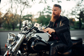 Biker sitting on a motorcycle, classical chopper