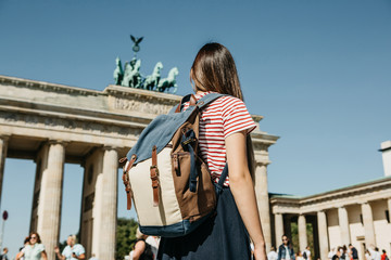 A tourist or a student with a backpack in Berlin in Germany visits the sights. Ahead is the...