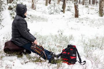 it is cold in winter, it is snowing. Girl with a compass map and odometer in hand, paves the route. there is toning