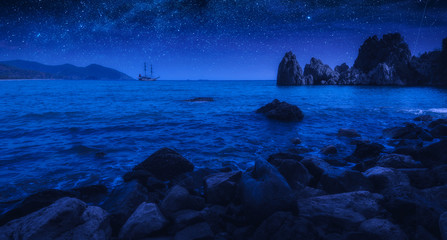 Sailboat on a horizon in mediterranean sea bay at night
