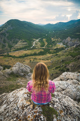 Young girl sitting on a rock