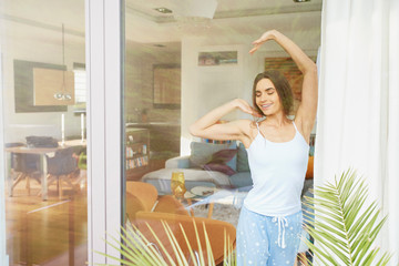 Beautiful young woman stretching after waking up morning