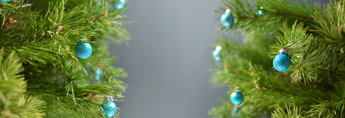 Decorated Christmas tree branches with blue ornaments. Christmas background with empty space in the...