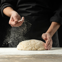 Fototapeta premium A professional cook in a professional kitchen prepares flour dough to make bio-italian pasta. concept of nature, italy, food, diet and bio.Frost in the air