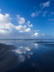 Naklejka na ściany i meble Beautiful cloud and blue sky reflections at Westward Ho! beach in the wet sand