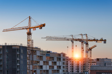 Construction cranes work in thef Helsinki in winter - 238070038