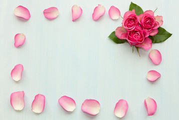 Floral frame made of pink roses on light background.