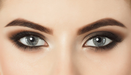Beautiful woman with long eyelashes and with beautiful evening make-up. Eyes close up. Looking at...