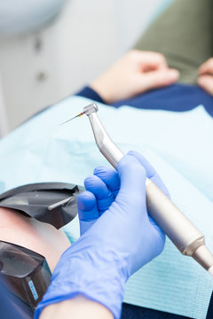 Closeup picture of dental instruments: drill and needle for root canal treatment and pulpitis in hand at the dentist
