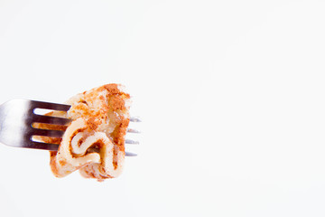 Pancakes stuffed with braised apples sprinkled with cinnamon on a fork