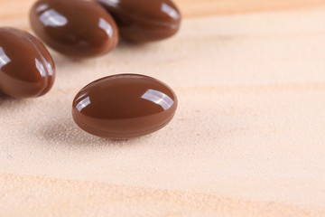 Medications for the treatment of diseases. Capsules on wooden background.