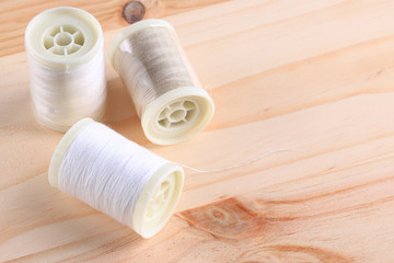 Bobbins with threads on the background of an old wooden table