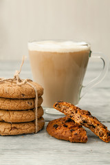 Cup of coffee with American cookies on grey wooden background