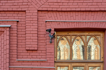 Surveillance cameras pointing in different directions on a brick wall