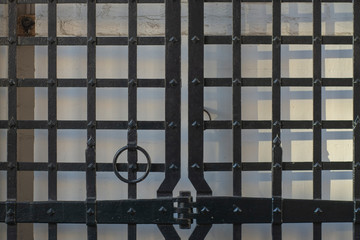 Background with an open gate in the form of a metal grille with rivets