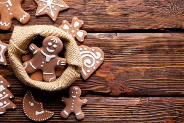 Gingerbread cookies in jute bag on wooden table as Christmas symbols