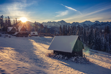 Wooden mountain hut in the morning, snowy winter