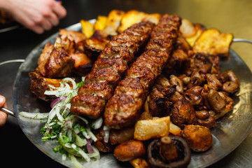 Lula kebab with vegetables. Minced mutton chop on the big steel plate