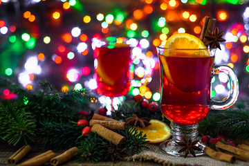 Christmas mulled wine with spices on wooden table. Hot drink on lights background.