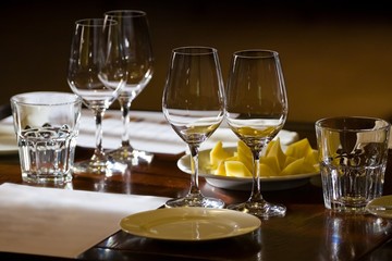 wineglasses and glasses, plates and cheese on a table ready for wine testing in a restaurant