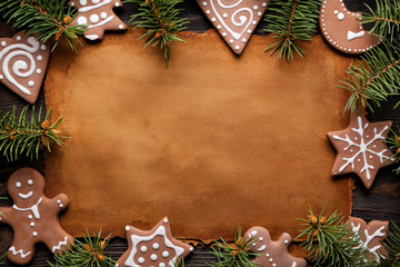Christmas cookies, branch of spruce tree and handmade paper sheet on wooden table