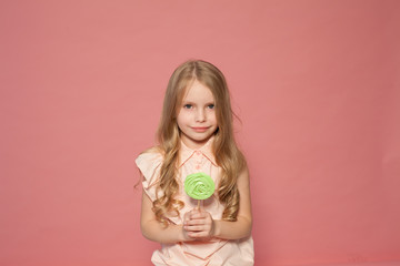 beautiful little girl blonde with cake and candy portrait of food