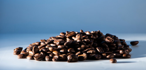 Coffee beans spilled on a bright blue background