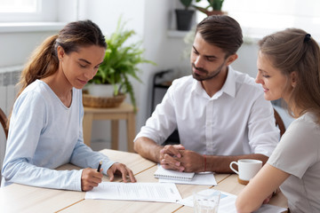 Mixed race client hold pen put signature at official paper make buy or sell deal sitting with...