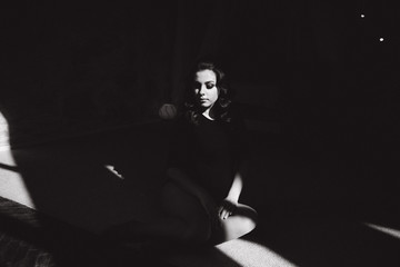 Young pregnant woman sit near the window. Sun rays fall on woman