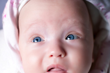 Beautiful newborn girl with amazing eyes. Surprised attentive glance. Selective focus.