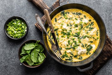 omelette with spinach and cheese in a pan on the concrete background top view - 238077851