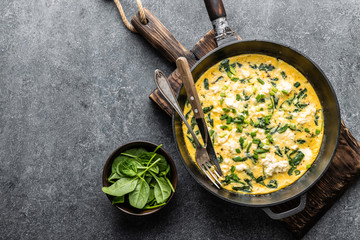 omelette with spinach and cheese in a pan on the concrete background top view - 238077899