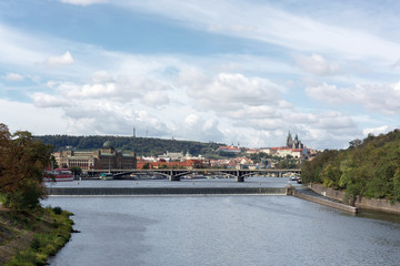 Fototapeta na wymiar Prague panorama with Stefanik bridge, Vltava river, colorful rooftops, Petrin tower, Prague Castle and St. Vitus Cathedral in the distance, on a cloudy summer day