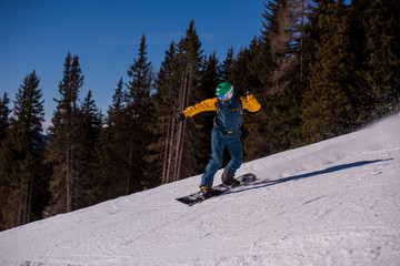 Fototapeta na wymiar snowboarder running down the slope and ride free style