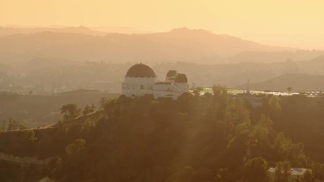 Cinematic Aerial of Griffith Observatory with  The Hollywood  Sign as background / Los Angeles, California 