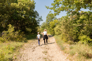 Fototapeta premium Mum and son hiking on a stone path in the wildness