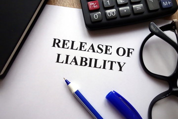 Release of liability document, pen, glasses and   calculator on desk