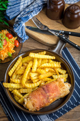 Fried chicken breast stuffed with mushrooms and cheese wrapped in ham served with fries and salad.