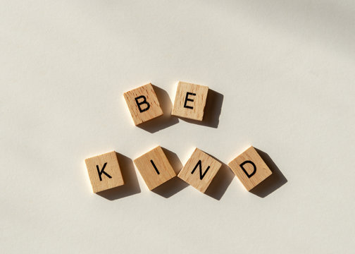 Naklejki Be kind spelled in wooden letter tiles flat lay