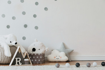 Stylish scandinavian newborn baby interior with mock up photo poster frame on the pattern wall,...