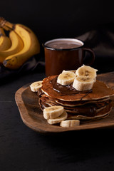 pancakes and banana on wooden plate