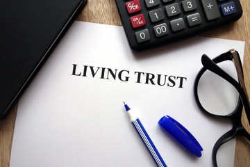 Living trust document, pen, glasses and calculator on   desk