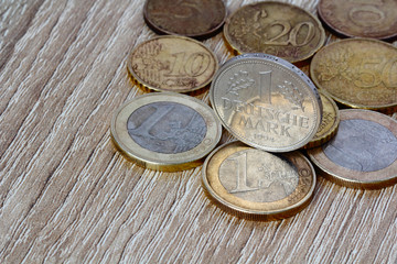 Old German Currency Deutsche Mark and coins euro. The concept of a disintegrating European Union. Wooden background