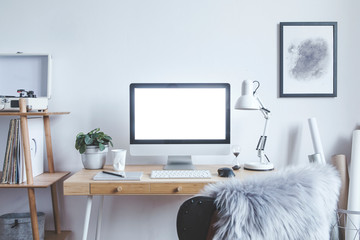 Stylish scandinavian interior of home creative desk with mock up computer screen, poster frame,...